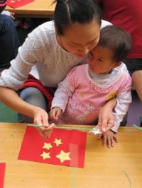 9月23日下午3点，小班组的孩子们在爸爸妈妈的陪同下，同老师们一起齐唱国歌、一起剪剪贴贴做国旗。做得可认真了！瞧，当孩子们手里挥舞着做好的国旗,心里甭提多高兴了!