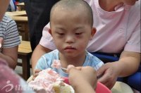 爱心人士在给孤残儿童喂蛋糕